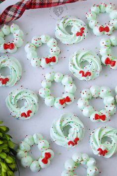 green frosted pretzels with red bows and sprinkles on them