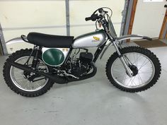 a dirt bike parked in a garage next to a wall with a sign on it