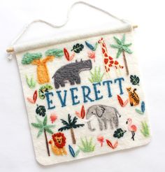 an embroidered sign that says, everet with animals and palm trees on the front