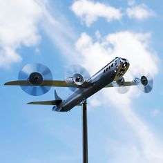 a model airplane flying in the air on a sunny day with blue sky and clouds