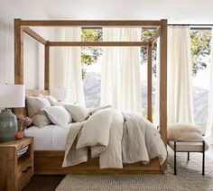 a bed with white linens and pillows in a bedroom next to a large window