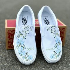 These White Slip On Vans have a soft flower design with gorgeous light blue flower arrangements and lush light green accents. These are the perfect and comfortable gift for wearing on the big day while also enjoying them after the fact while out for brunch and reminiscing on saying "I Do". Add a custom date and initials! The perfect shoes to get personalized. Want this design with orange flowers? Shop here: https://bit.ly/3Wq0Mtw We source each pair of blank shoes brand new directly from Vans. T Embroidered Shoes Diy, Bridal Vans, Painted Wedding Shoes, Custom Slip On Vans, Shoes Artwork, Sneakers Wedding, Wedding Vans, Wedding Shoes Sneakers, Embroidered Vans