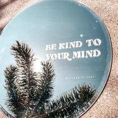 a round glass plate with the words be kind to your mind written in white on it