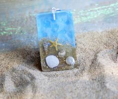 a candle with shells and starfish on the sand