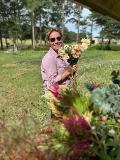 a woman is holding flowers in her hands