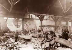 an old black and white photo of men working in a factory