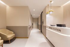 a long hallway with two chairs and a reception counter