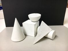 three pieces of white pottery sitting next to each other on top of a countertop