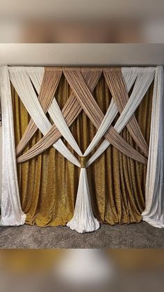 a gold and white backdrop with drapes