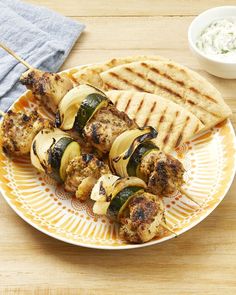 grilled chicken and vegetable kabobs on a plate with pita bread