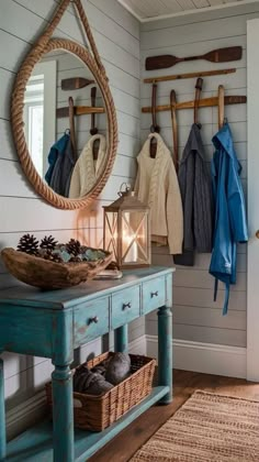 a blue table with a mirror and some clothes hanging on the wall next to it