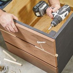 a man is drilling holes in a wooden box with two drillers on it and the word spacer below