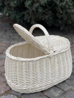 a white wicker basket sitting on the ground