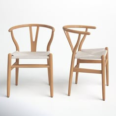 two wooden chairs sitting side by side on a white surface with one chair facing the other