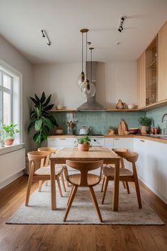 a wooden table sitting in the middle of a kitchen next to a potted plant