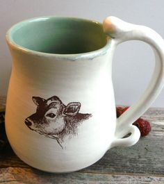 a ceramic mug with a drawing of a cow on it