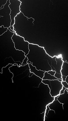 a black and white photo of lightning in the night sky