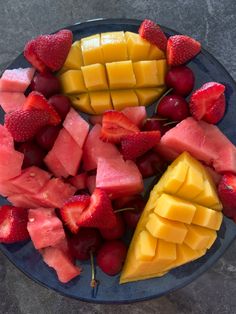 a blue plate topped with sliced fruit and watermelon