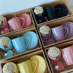 six different colored coffee mugs are in the same box, one is blue and one is pink