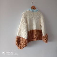 a white and brown sweater hanging on a wall