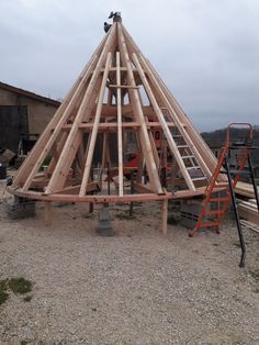 a large wooden structure sitting on top of a dirt field