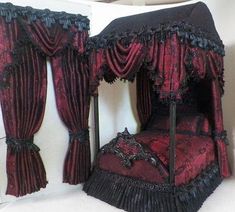 a bed made out of fabric with curtains on the top and bottom, sitting in front of a mirror