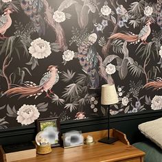 there is a wall paper with birds and flowers on it in the room next to a bed