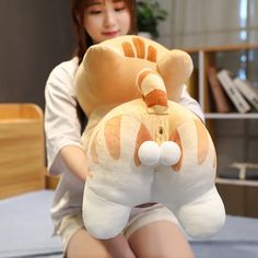 a woman sitting on a bed holding a large stuffed animal