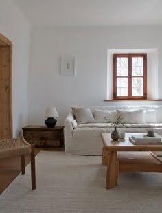 a living room filled with furniture and a white couch next to a wooden coffee table