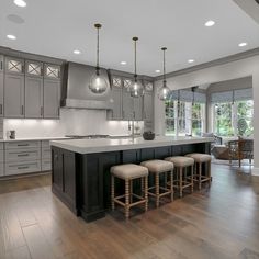 a large kitchen with wooden floors and gray cabinets