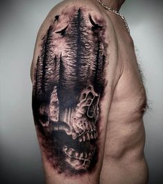 a man's arm with a black and grey tattoo on it, depicting a forest scene