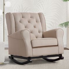 a living room with a rocking chair and potted plant