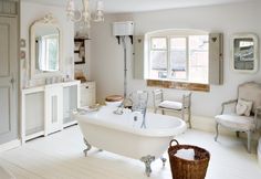 a bathroom with a claw foot tub and chandelier