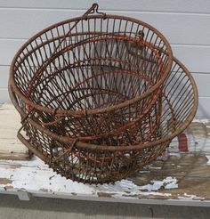 two brown baskets sitting on top of a wooden table next to a white wall and snow