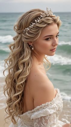 a woman with long blonde hair wearing a tiara on the beach near the ocean