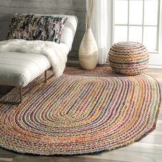 a living room with a white couch and rugs on the floor next to a window