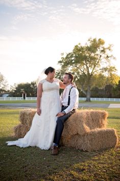 a bride and groom sitting on hay bales