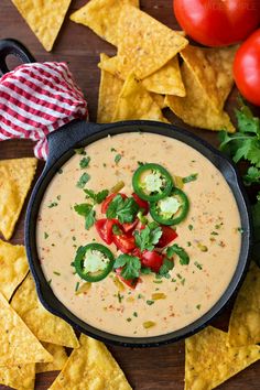 a bowl of quesadilla dip surrounded by tortilla chips and tomatoes