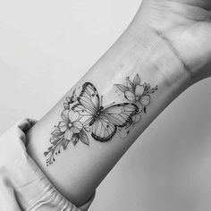 a woman's arm with a butterfly tattoo on the left side of her wrist