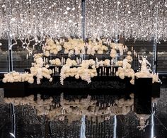 an arrangement of white flowers and chandelier hanging from the ceiling