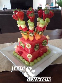 a cake made out of watermelon, grapes and strawberries