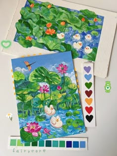 two cards with water lilies and birds on them next to colored pencils,