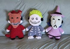 three crocheted dolls are sitting on a bed