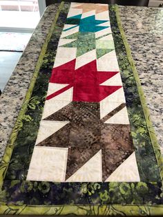 a quilted table runner on top of a granite counter