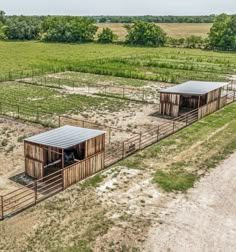 an aerial view of two buildings in the middle of a field