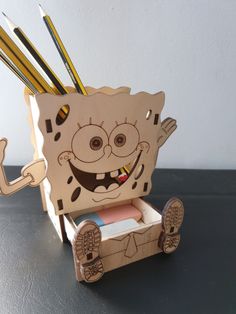 a cardboard box with pencils in it and a cartoon character on the inside that has been cut out