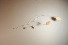 a mobile with leaves hanging from it's sides on a wall in a room