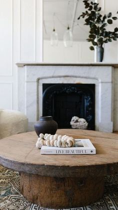 a living room with a fire place and a coffee table in front of a fireplace