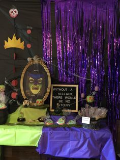 the table is covered with purple tinsel and decorations for an evil clown themed birthday party