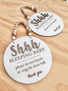 two personalized wooden signs on a table with wood beads and bead necklaces